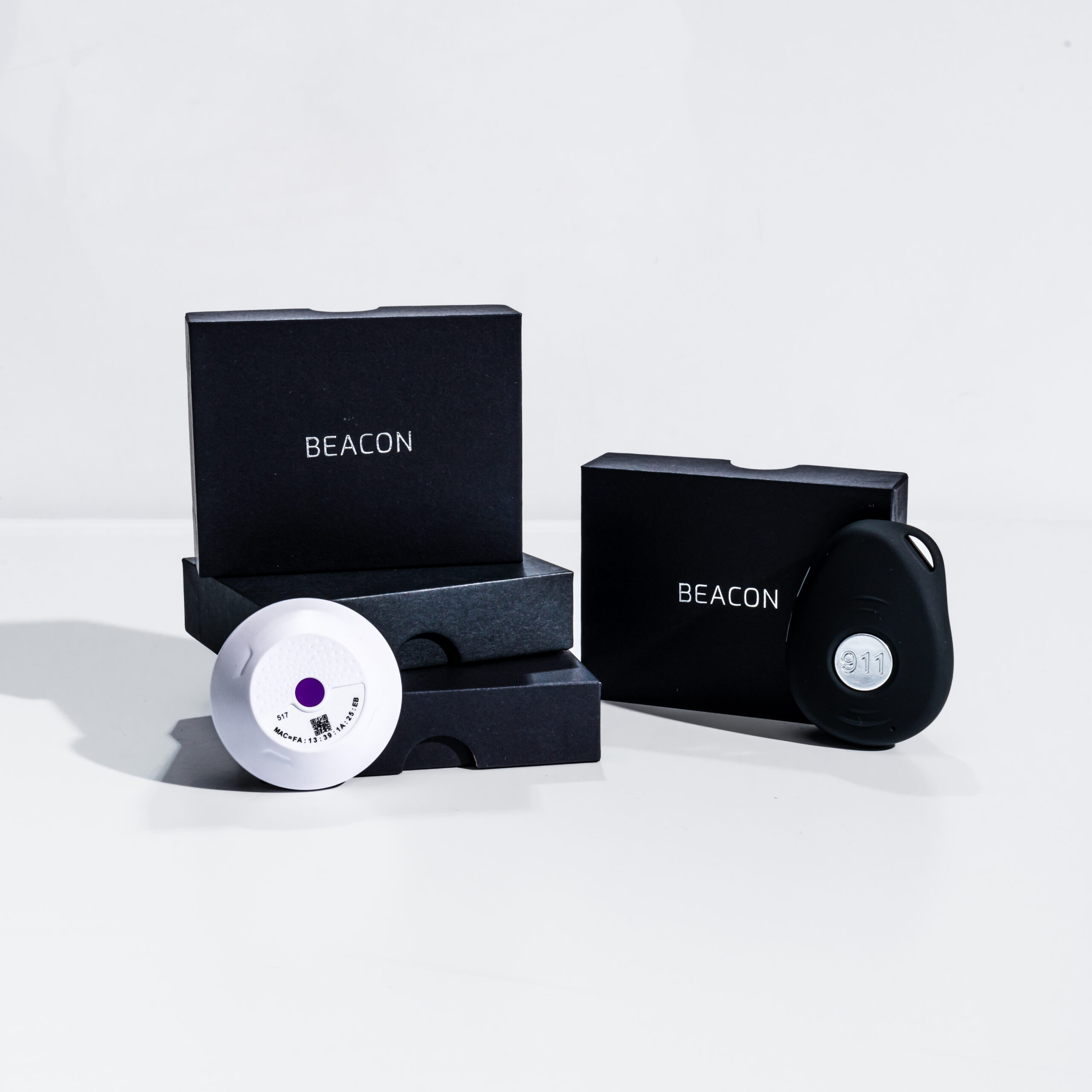 Beacon panic button device and BLE room beacon shown with branded packaging